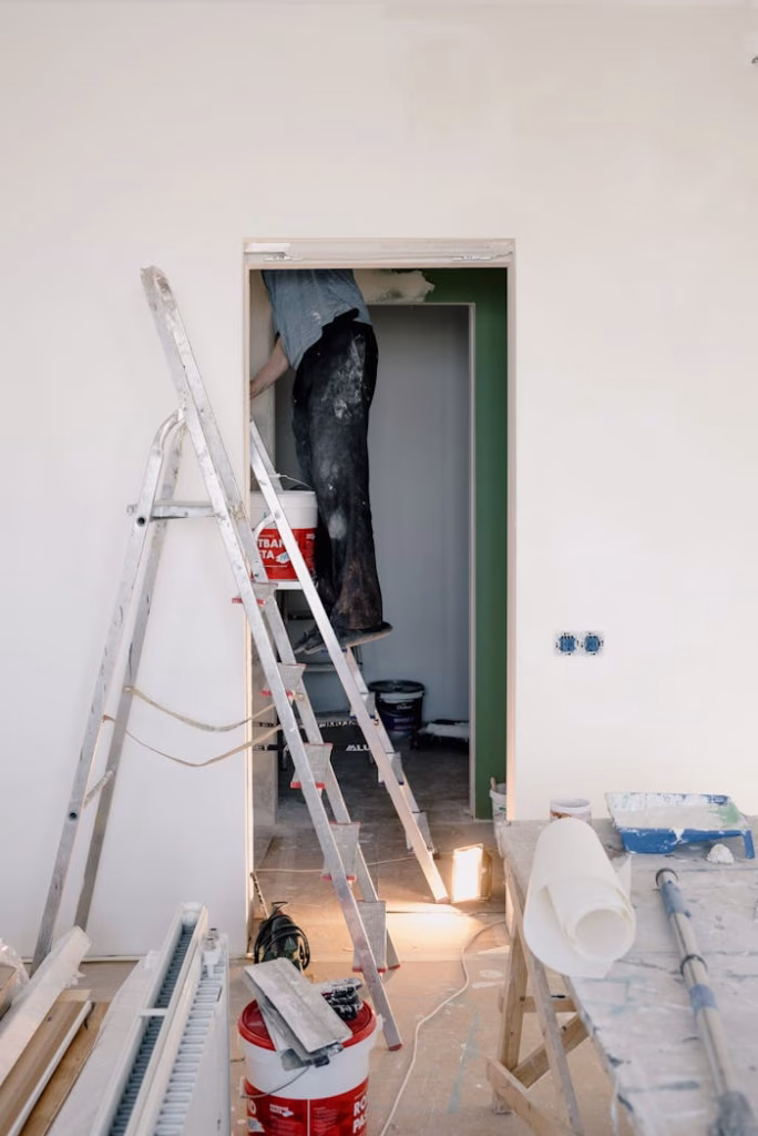 Crop unrecognizable male in dirty clothes working in room during renovation works at home