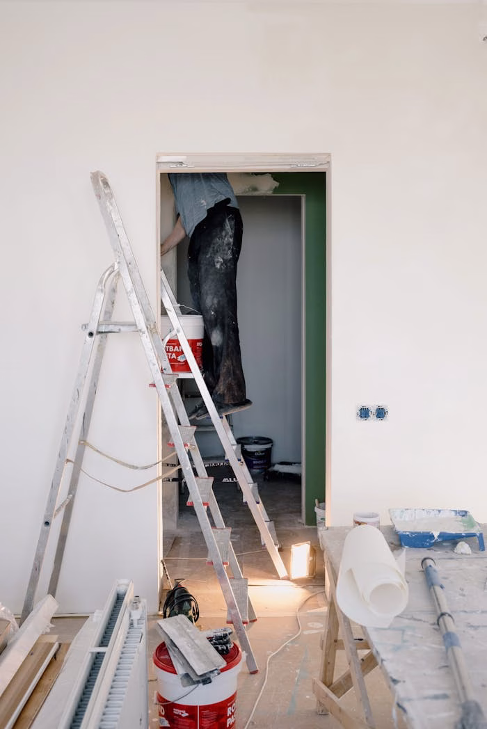 Crop unrecognizable male in dirty clothes working in room during renovation works at home